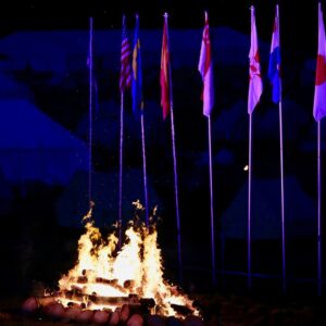 The campfire at Blair Atholl Jamborette, with the international flagpoles lit up behind