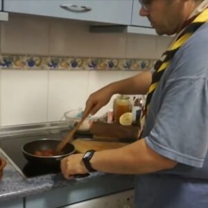 A picture of a Scout leader cooking chorizo